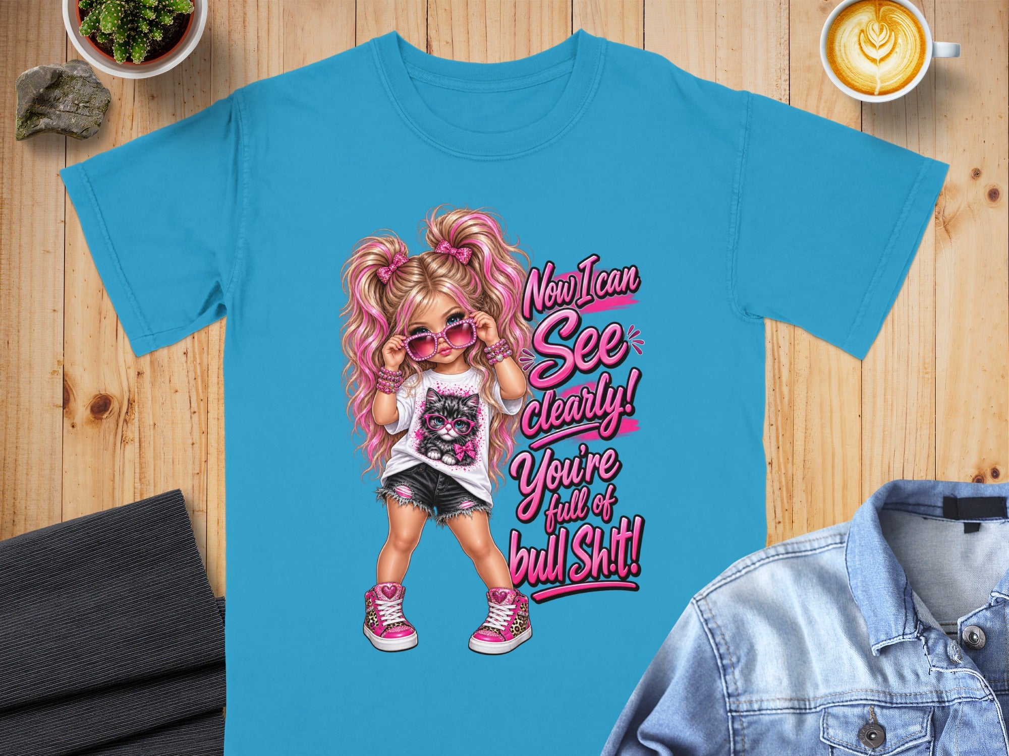 Turquoise t-shirt with cartoon girl and cat graphic and text "Now I can See clearly! You're full of bull Sh!t!".