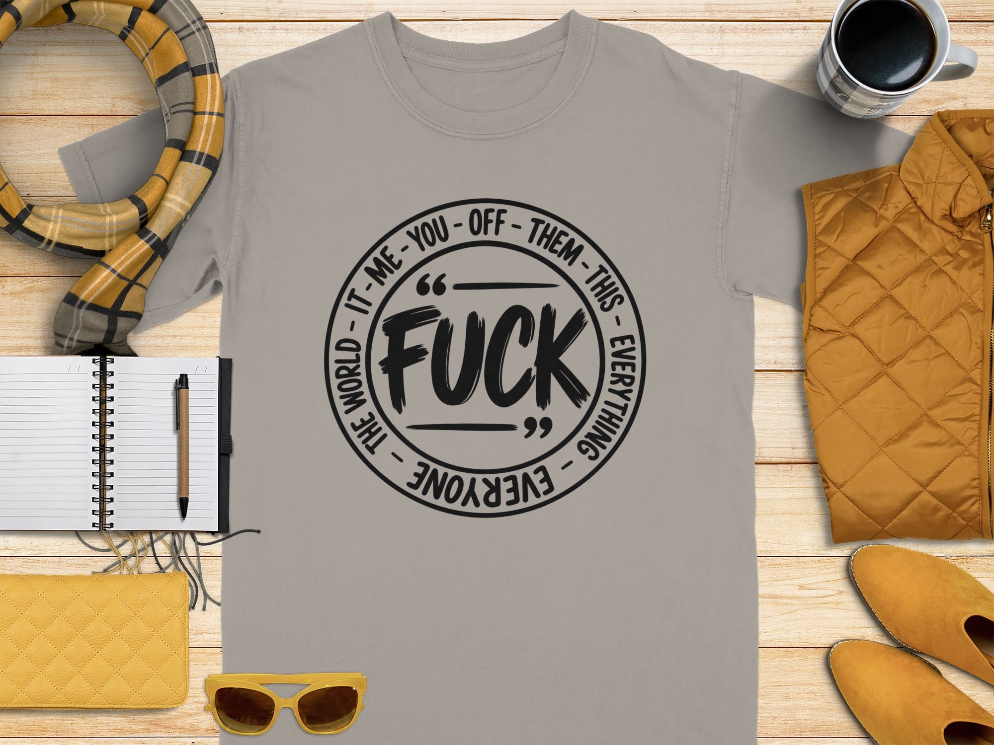 Light gray t-shirt with black text reading "FUCK" in a circle, surrounded by "THE WORLD - IT - ME - YOU - OFF - THEM - THIS - EVERYTHING - EVERYONE".