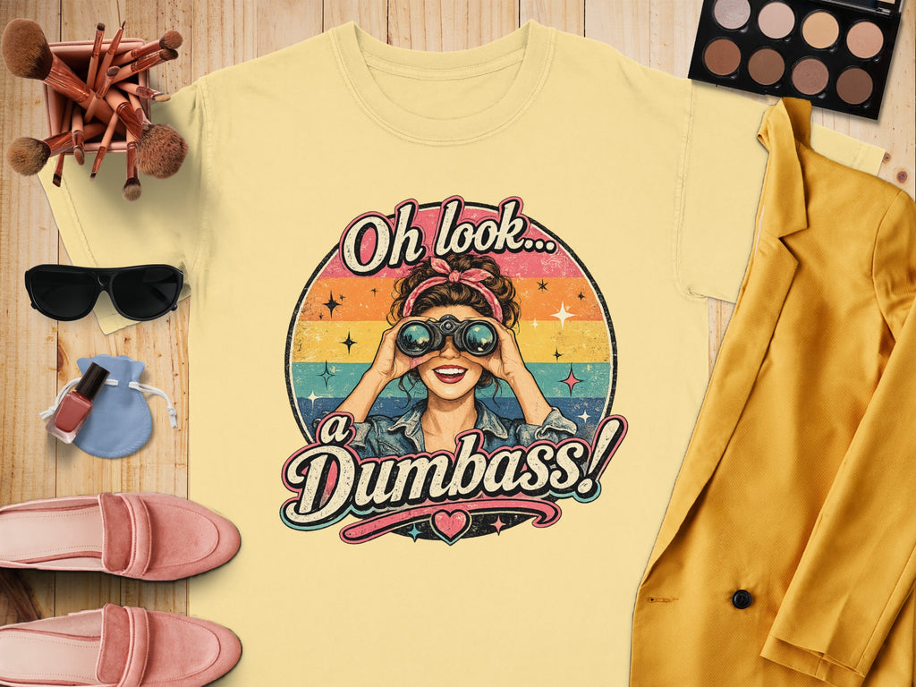 Yellow t-shirt with graphic of woman looking through binoculars, text "Oh look... a Dumbass!".