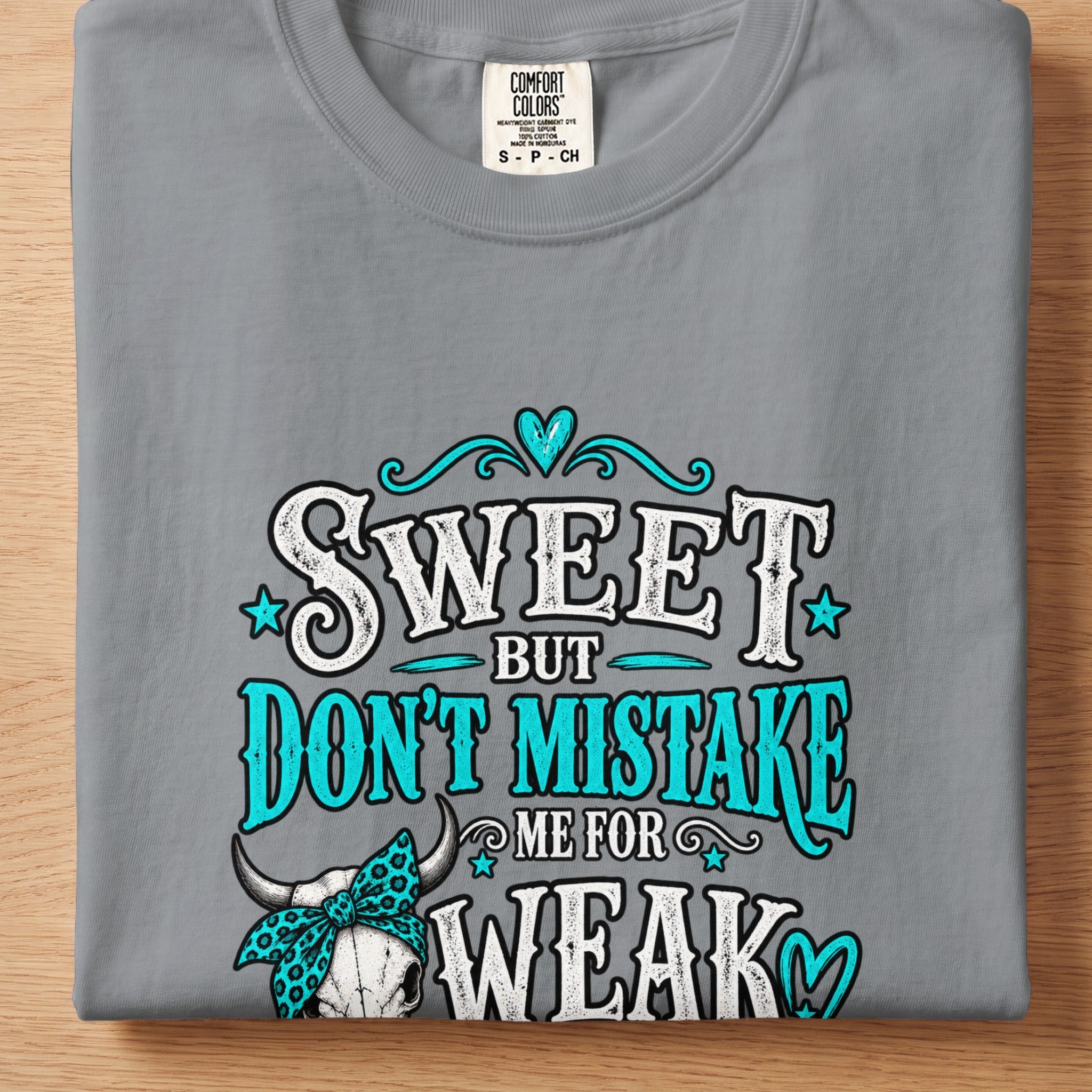 Gray t-shirt with "Sweet but don't mistake me for weak" text and bull skull graphic.