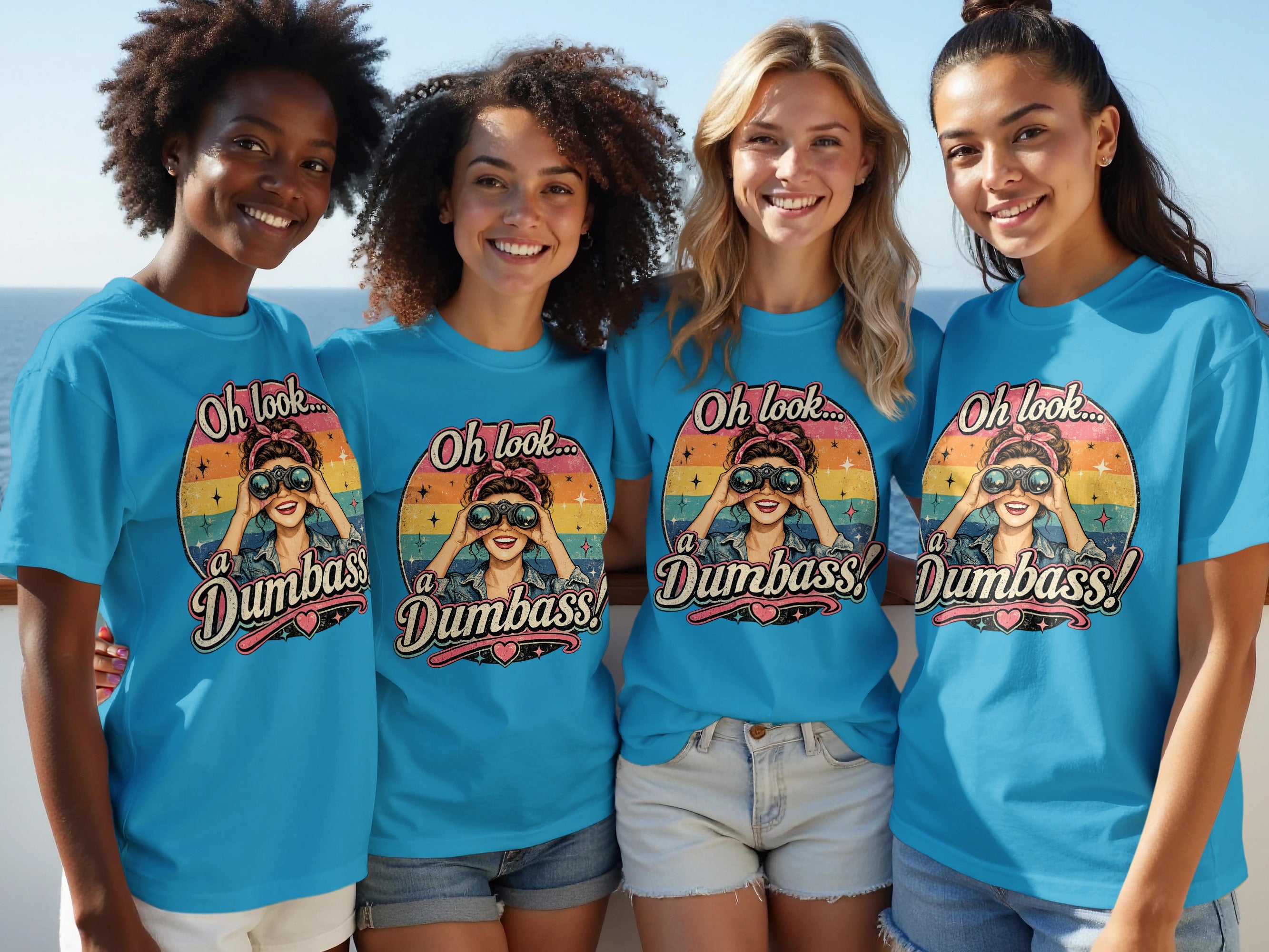 Four smiling women wear matching blue shirts with a retro graphic of a woman looking through binoculars.