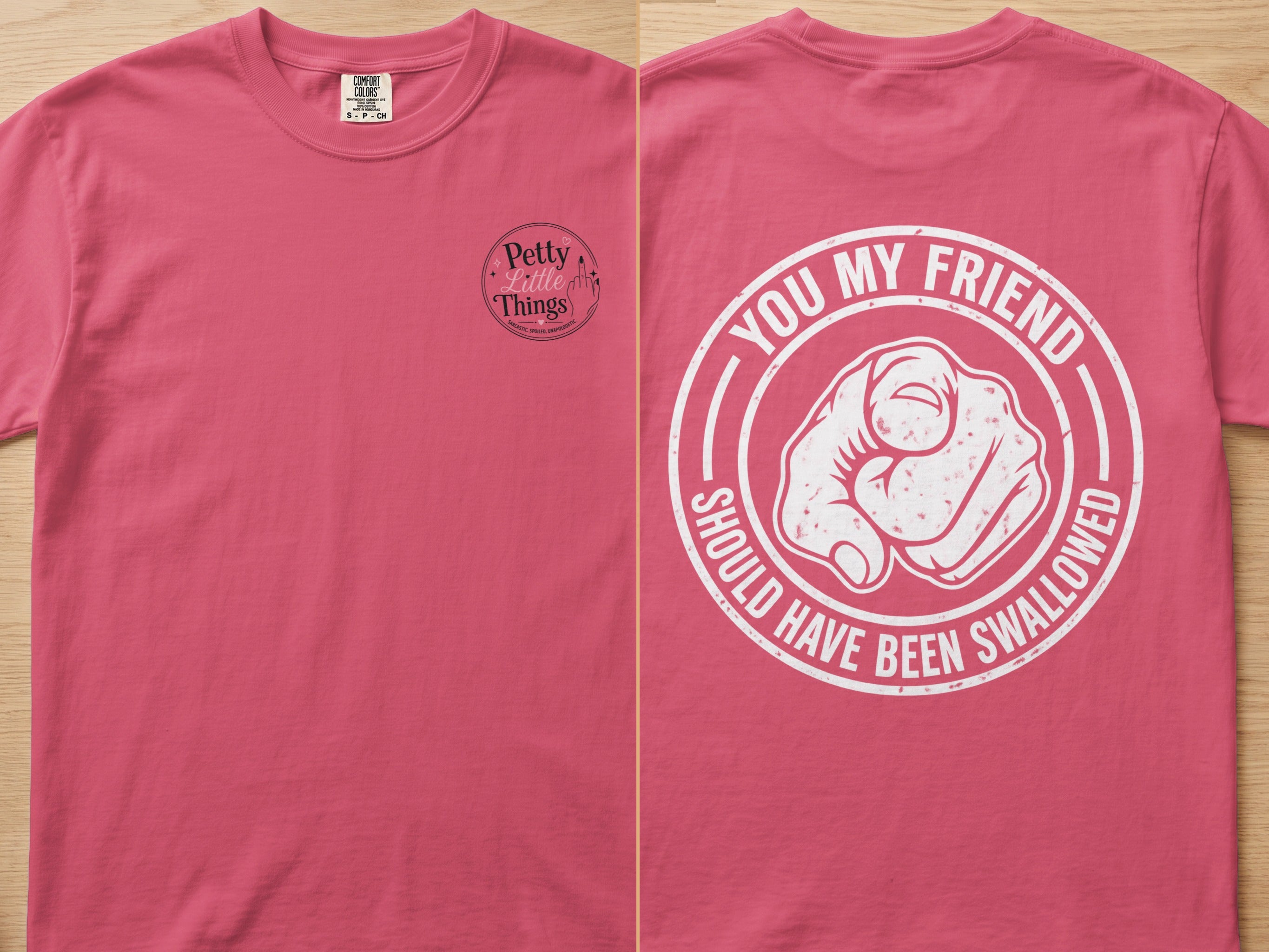 Pink t-shirt with "Petty Little Things" logo on left and graphic saying "You my friend should have been swallowed" on right.