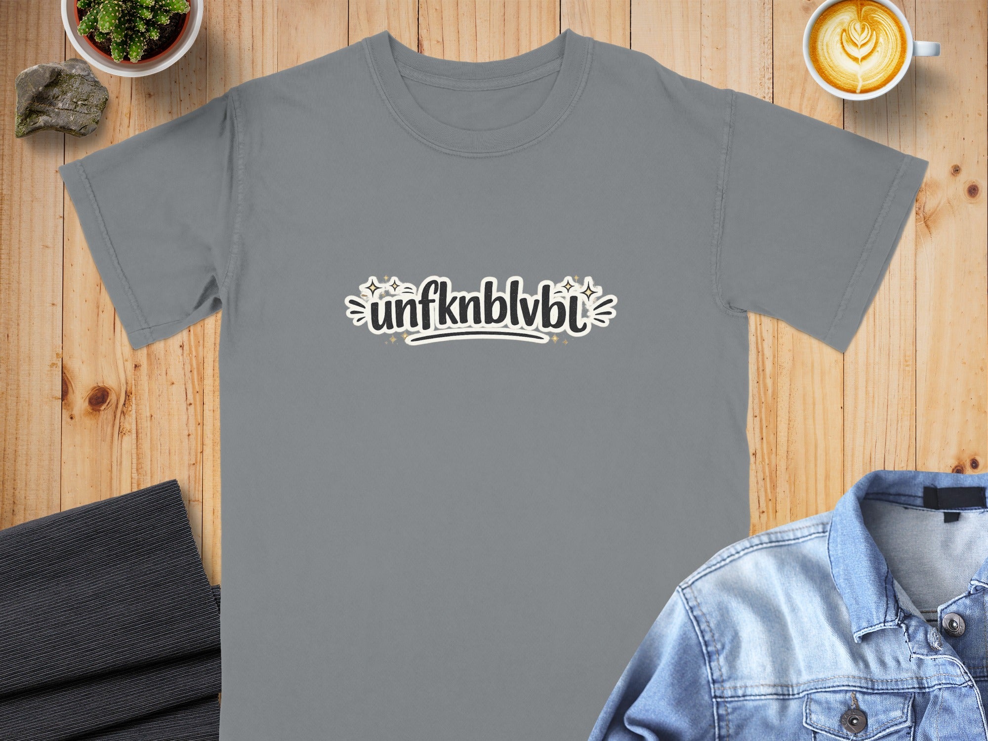 Grey t-shirt with "unfknblvbl" text and stars graphic.