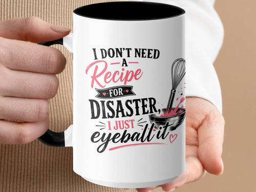 White mug with black interior and handle, featuring "I don't need a recipe for disaster, I just eyeball it."