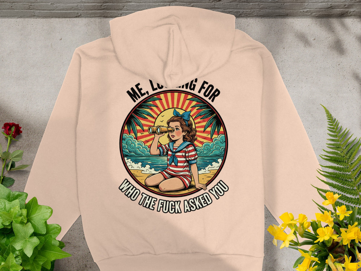 Peach hoodie with a retro graphic of a girl with binoculars looking out to sea.