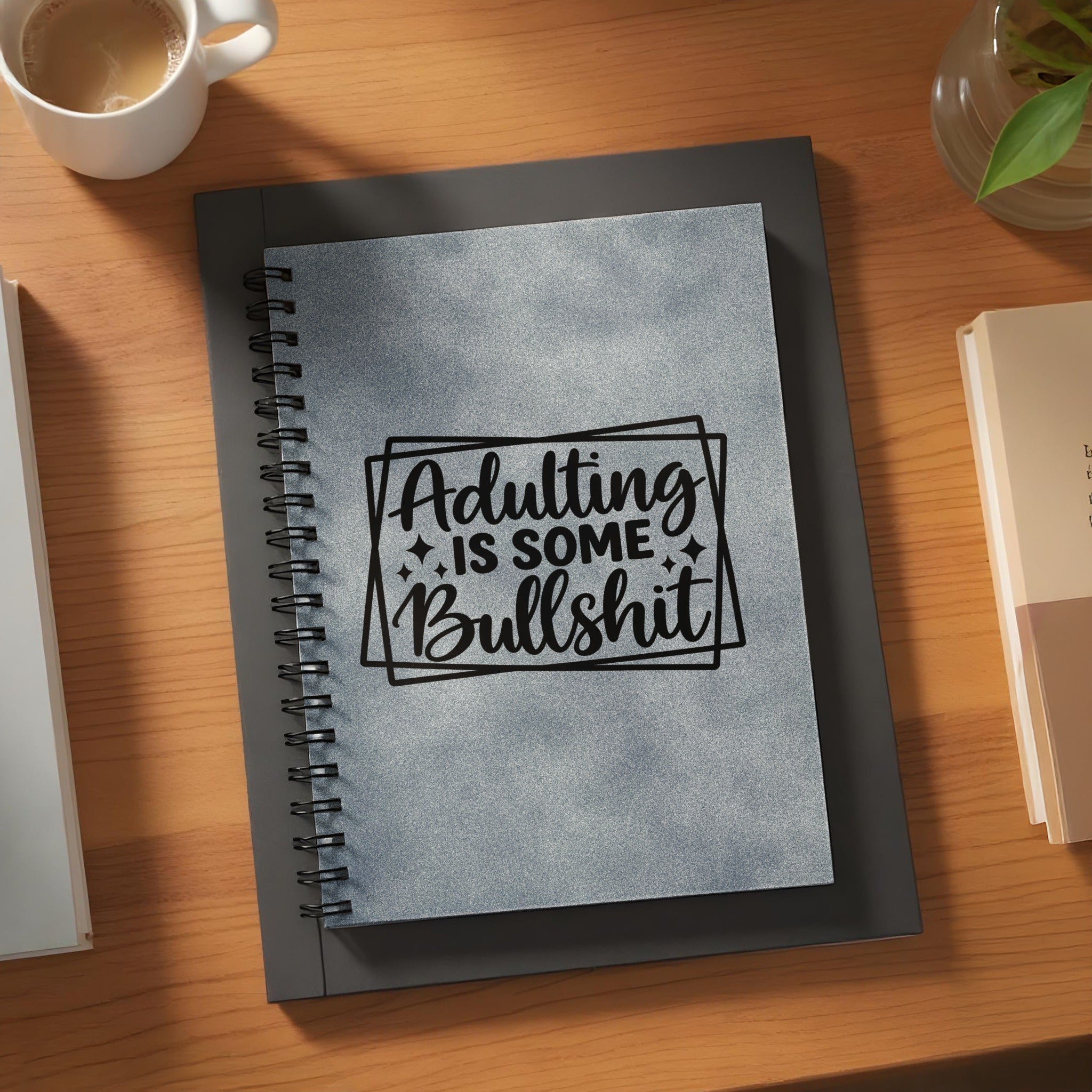 Gray spiral-bound notebook with black text "Adulting Is Some Bullshit".